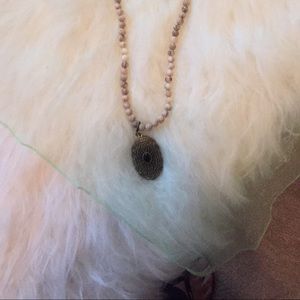 Long necklace beige beads and pendant.